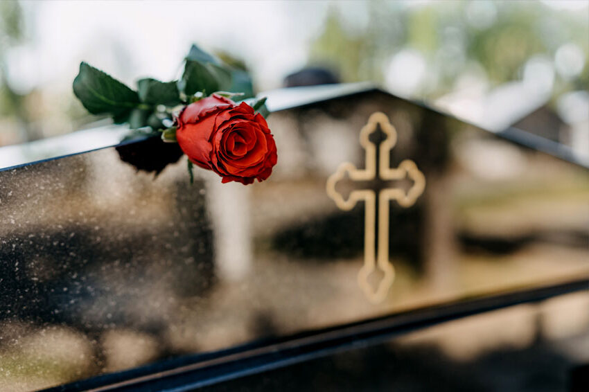 Róż na grobowcu symbolizująca ostatnie pożegnanie. Zdjęcie koncepcyjne dla działu zakresu usług pogrzebowych
